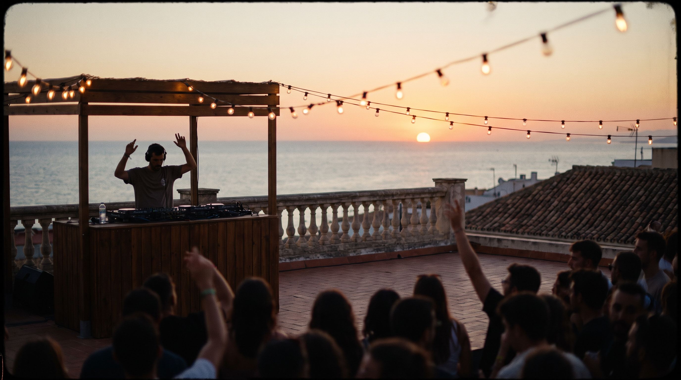 A rooftop DJ session in Málaga at sunset, the sea on the horizon